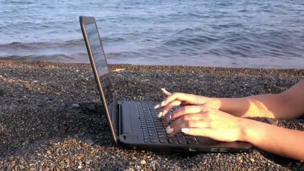 Девушка за ноутбуком на пляже — стоковое видео
