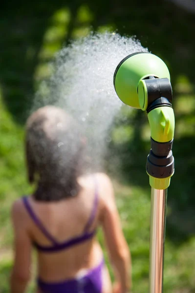 A menina toma um banho no jardim em um dia quente de verão — Fotografia de Stock