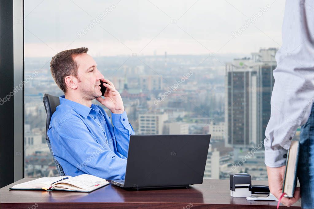 manager office / manager hard works in the office on the top floor building  next to the window