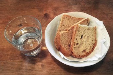 ekmek ve bir bardak su ahşap masada, yoksulluk ve basitlik kavramı