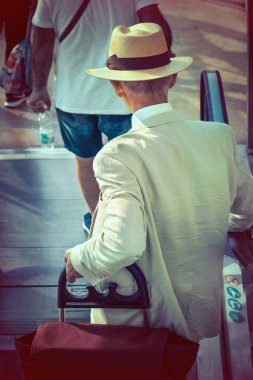 Son sınıf öğrencisi geziye çıkıyor. Tramvay çantalı yaşlı adam havaalanındaki yürüyen merdivenlerden iniyor.