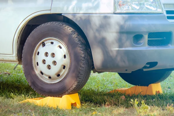 prevent the wheels from moving. Parked car on the lawn, land vehicle uses two object to block the car movement