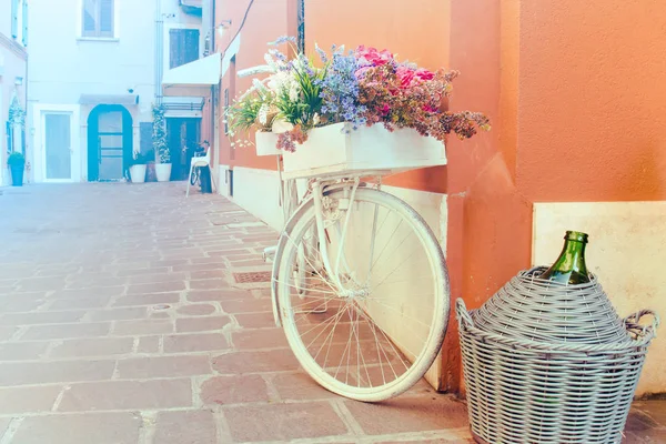 Decorative mediterranean bicycle. White bike with flowers and a flask of wine (copy space available on the left)