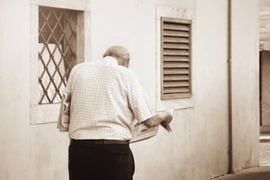 Gazete okuyor, yalnız ve sokakta yürüyor (sepya vintage etkisi))