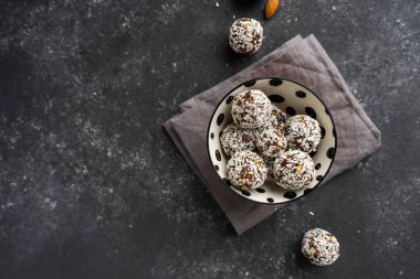 Siyah arka planda fındıklardan ve tarihlerden ham tatlılar