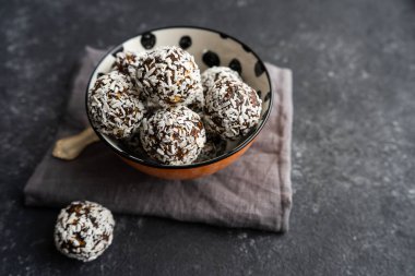 Fındıklardan çiğ yemek topları ve siyah arka planda tarihler.