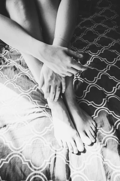 Girl sitting on bed hands legs without face — Stock Photo, Image