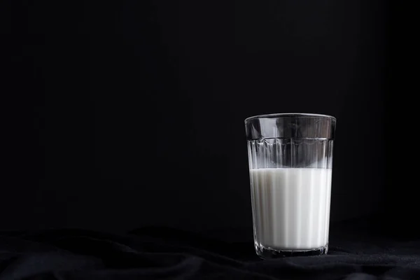 Ein Glas Milch auf schwarzem Hintergrund — Stockfoto