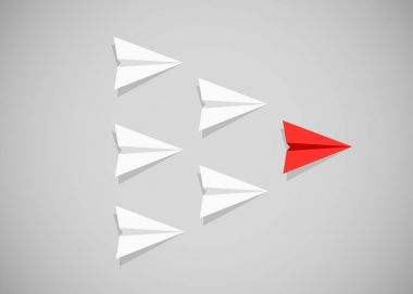 Beyaz uçaklar arasında bir lider olarak kırmızı kağıt uçak. Liderlik, takım çalışması, motivasyon kavramı.