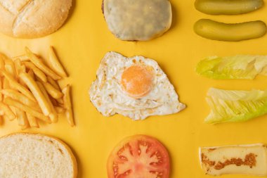 Sarı arkaplanda hamburger yapmak için gerekli malzemeler