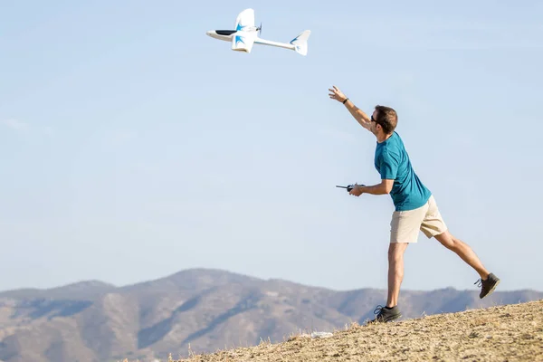 Hombre joven estableciendo plano de control remoto en el aire Fotos de stock