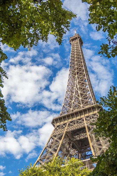 Eiffel Tower in green trees on blue sky — Stock Photo, Image