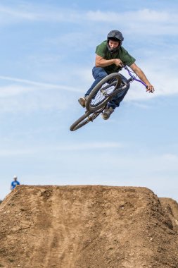 Genç adam dirtjump bisiklet üzerinde uçan