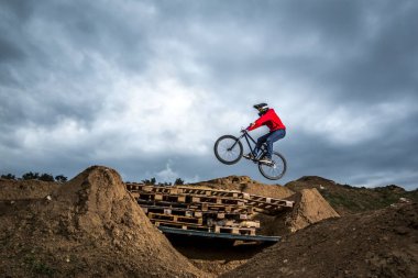 Genç adam dirtjump devre delik üstünden atlayarak