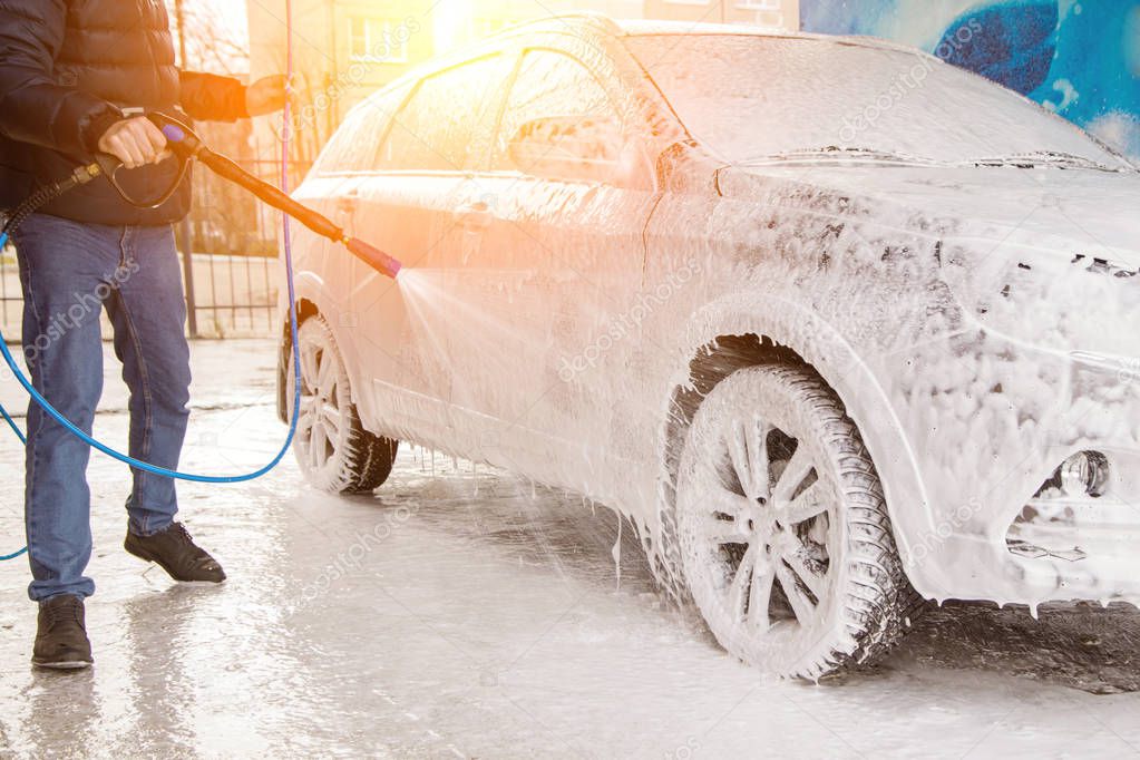 Man washing car. Cleaning car with foam