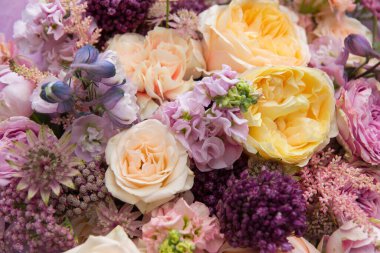 Beautiful mixed flowers bouquet with yellow and pink roses close-up, floral background