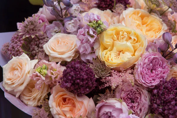 Wedding mixed flowers bouquet with yellow and pink roses close-up, floral background