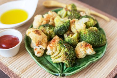 Fırında brokoli ve yeşil tabakta baharatlı karnabahar sebzeleri. Vegan sağlıklı diyet gıda konsepti