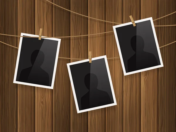 Photo frames fixed on the rope with clothespins on wood background. Vector. — Stock Vector