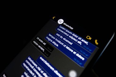 Torino, Italy- 10 Ekim 2019: Elinde bir telefon tutan kişi Whatapp 'ın karanlık modunu gösteriyor, popüler mesaj uygulaması.