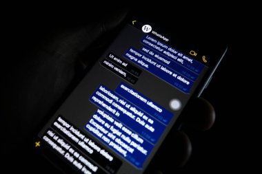 Torino, Italy- 10 Ekim 2019: Elinde bir telefon tutan kişi Whatapp 'ın karanlık modunu gösteriyor, popüler mesaj uygulaması.