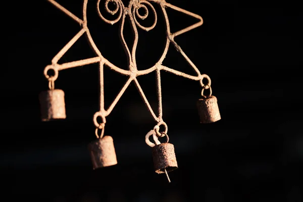 Wind chime in the form of a sun on black background at sunset — Stock Photo, Image