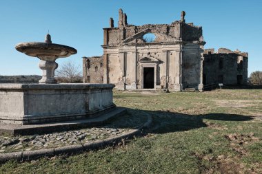 Monterano, Italy - January 27 2020: Abandoned church of San Bonaventura with octagonal fountain. Monterano is a ghost town near Rome