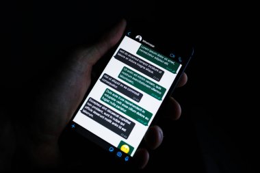 Torino, Italy- 19 Mart 2020: Bir telefon tutan kişi Whatapp 'ın karanlık modu, popüler mesaj uygulaması.