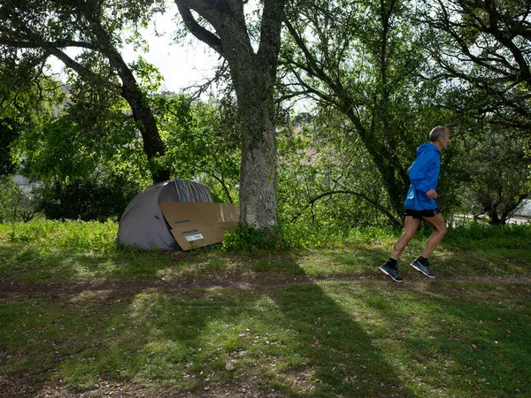 Karantinaya alınmış evsiz çadırı ve koşan adam. Portekiz 'de karantina
