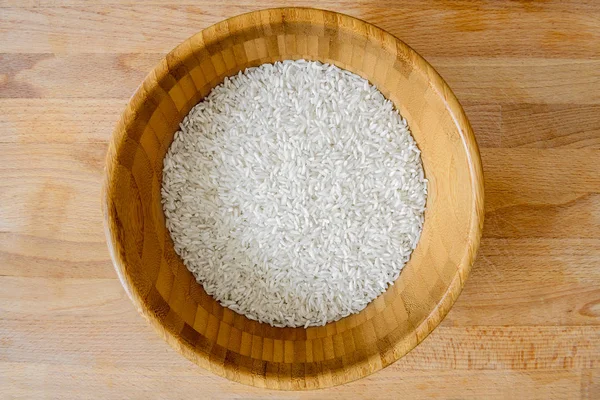 Τέλειο λευκό ρύζι σε ένα ξύλινο μπολ πάνω στον ξύλινο πάγκο — Φωτογραφία Αρχείου