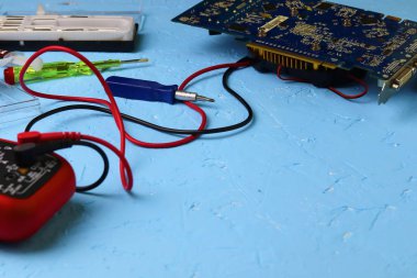 Erkek eller, bilgisayar ana kartının voltajını dijital multimetreyle ölçen Multimetr kullanarak elektronik bir cihazı tamir ediyor. Boşluğu kopyala - bilgisayar donanımı, dizüstü bilgisayar hizmeti kavramı