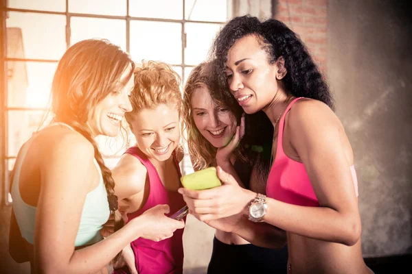 Vriendinnen kijken naar mobiele telefoon — Stockfoto