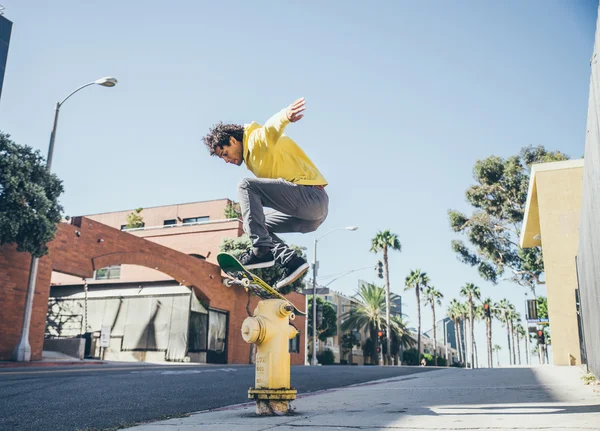 Skateboarder jumping over hydrant — Stock Photo, Image