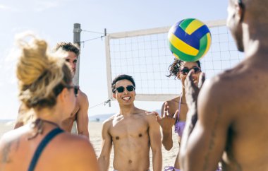 Plaj voleybolu oynarken arkadaşlar 