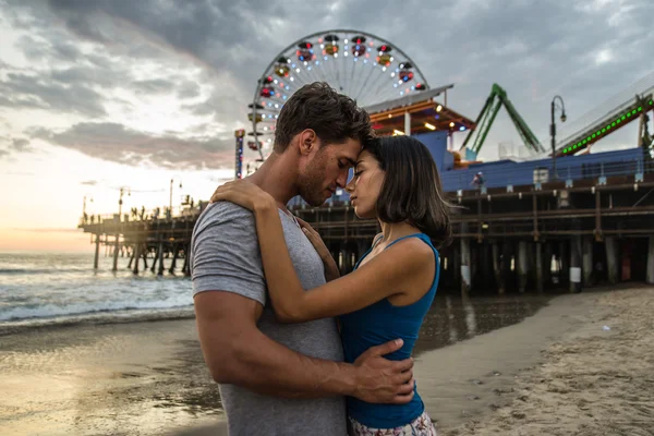 Paar zoenen bij zonsondergang op het strand — Stockfoto