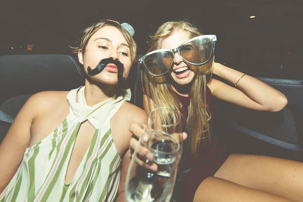 Meninas com champanhe em carro conversível — Fotografia de Stock