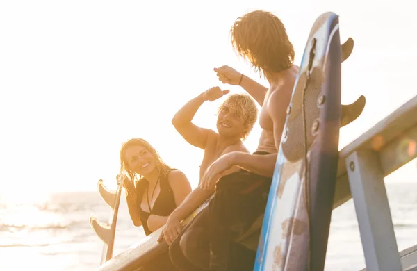 Groep van surfers plezier op strand — Stockfoto