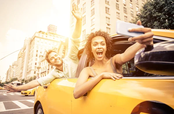 Heureux couple conduisant en taxi jaune — Photo