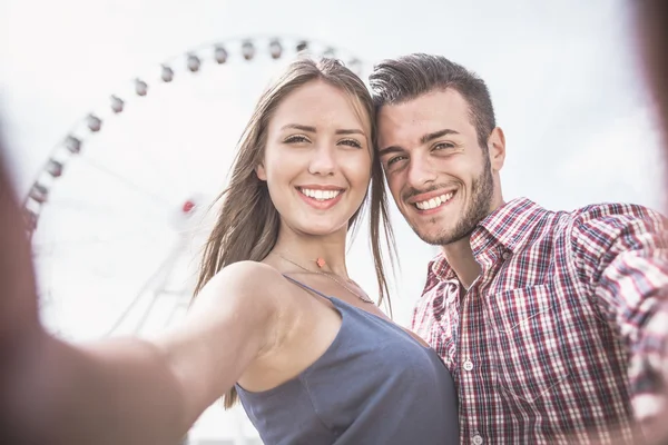 Couple taking selfie at amusement park — Stock Photo, Image