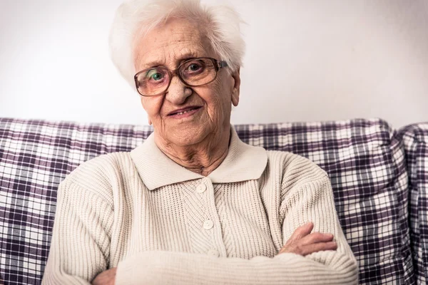 Yaşlı kadın kanepede — Stok fotoğraf