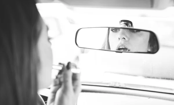 Femme mettant rouge à lèvres dans la voiture — Photo