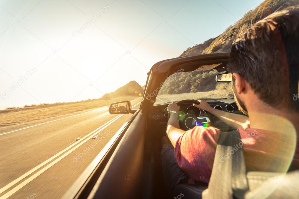 Man driving sport convertible car