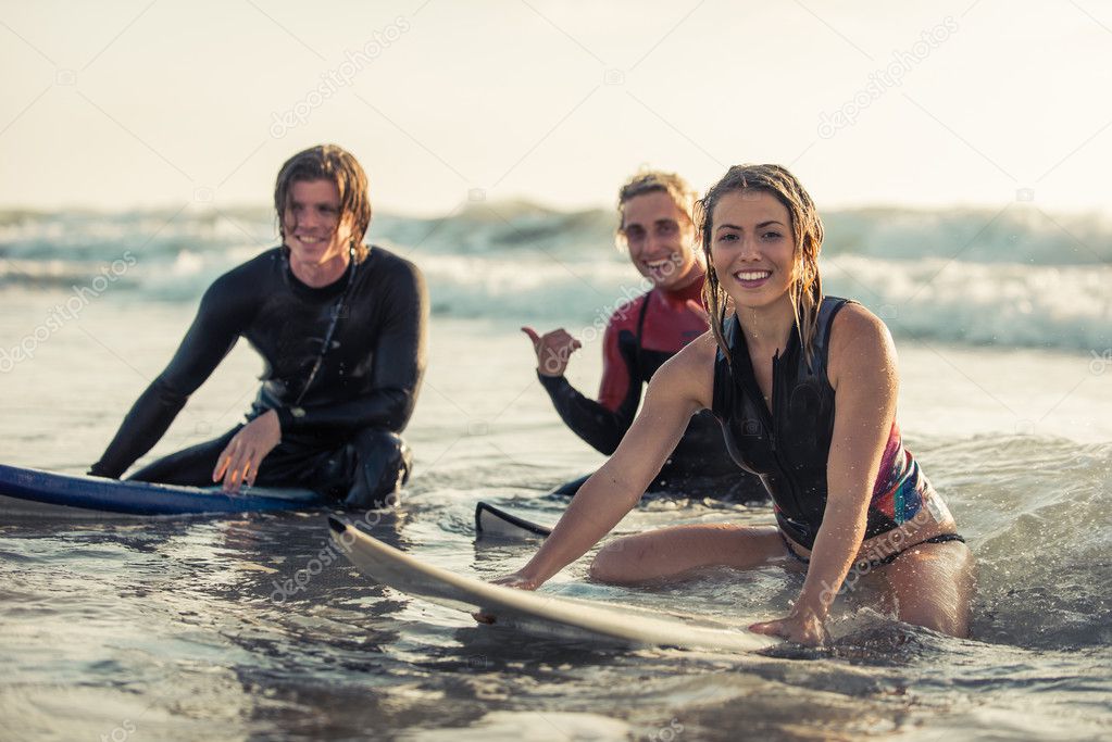 Group of surfers sitting on boards