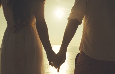 Romantik çift el ele tutuşuyor.
