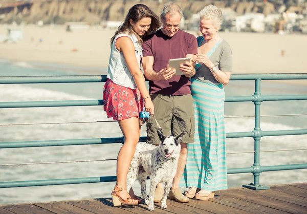 Χαμογελώντας οικογένεια με σκύλο που ψάχνει στο tablet — Φωτογραφία Αρχείου