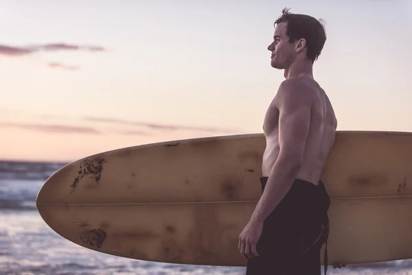 Surfer op strand bij zonsondergang — Stockfoto