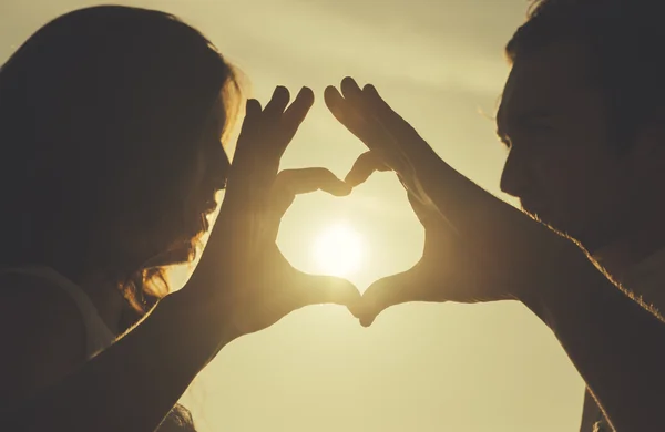 Couple making love symbol in sky — Stock Photo, Image