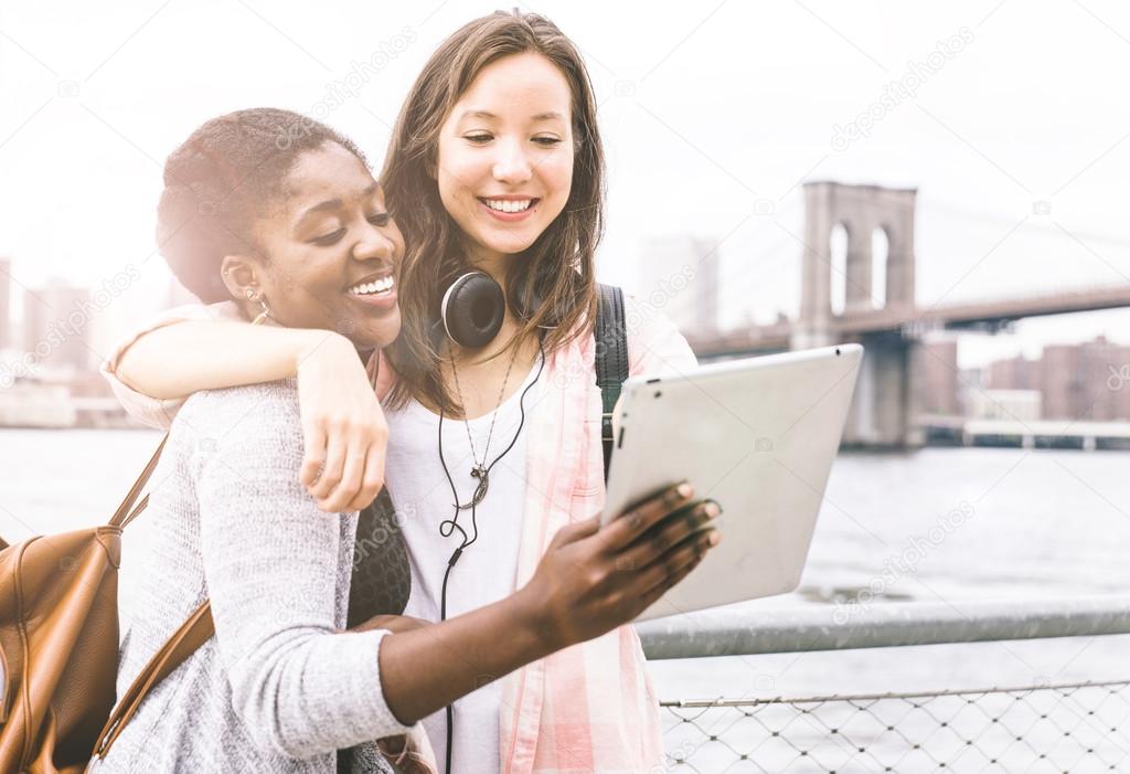 Friends looking at tablet near river