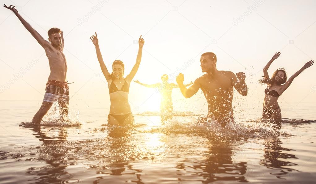 Happy friends splashing water