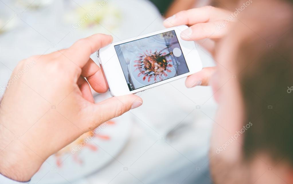Man photographing food with smartphone